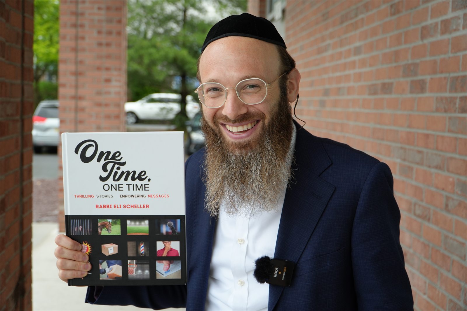 Rabbi Eli Scheller holding the One Time book